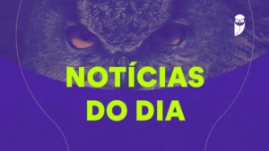 Pessoa estudando em um laptop, visualizando notícias de editais de concursos públicos, com livros e anotações ao redor.